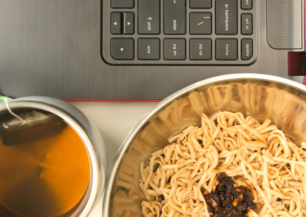 亚洲风格的方便面和茶旁边有一台笔记本电脑图片下载