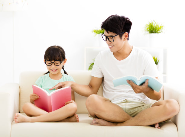 父亲和女儿一起在沙发上学习图片下载