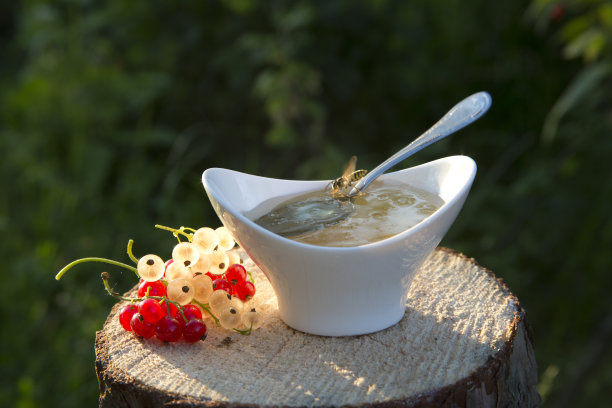 蜂蜜从勺子里倒出来。图片下载