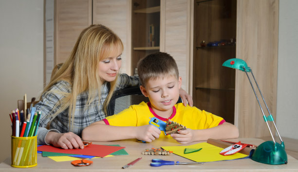 孩子在和妈妈一起做圣诞装饰。图片下载