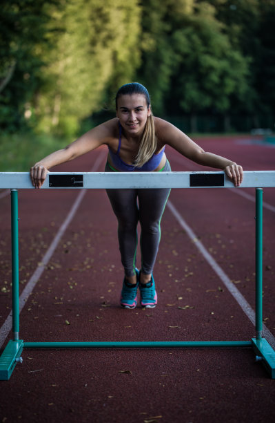 漂亮的运动女孩在体育场热身，图片下载