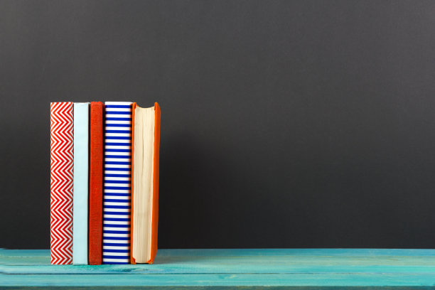 排彩色精装书，打开书在黑色的背景图片下载