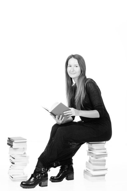 一个女人在一堆书上看书图片下载