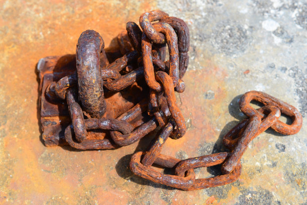 混凝土块上生锈的旧链条图片下载