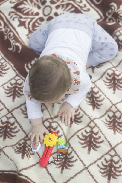 婴儿在毯子里玩。图片下载