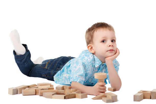小男孩在地板上和木制设计师玩图片下载