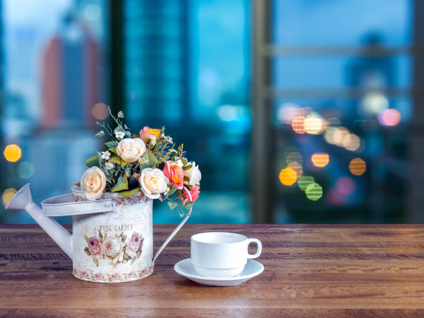 木桌面上的人造花瓶和咖啡杯图片下载
