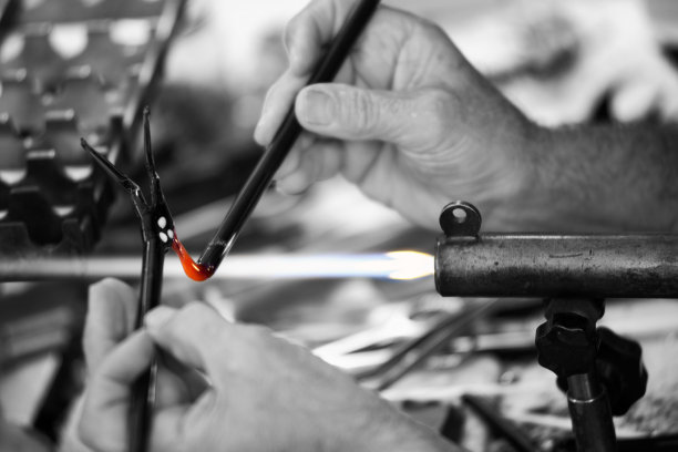 黑色和白色工匠的手与热玻璃工作图片下载