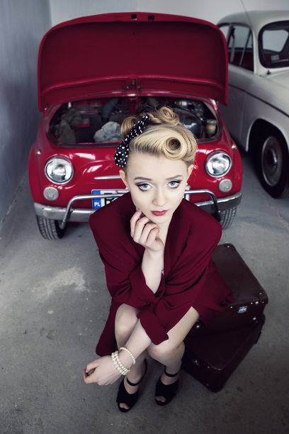 美女坐在旧行李箱上图片下载