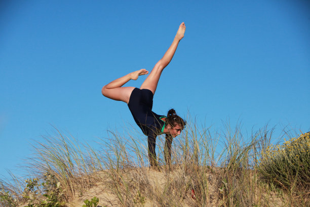 体操运动员在海滩上做倒立图片下载