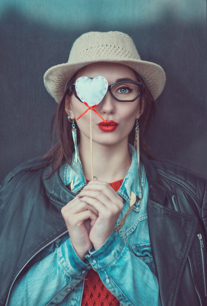 年轻漂亮的女孩戴着帽子和玩具心图片下载