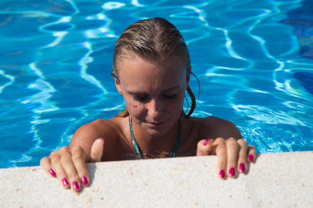 穿着比基尼的性感女孩在游泳池游泳图片下载