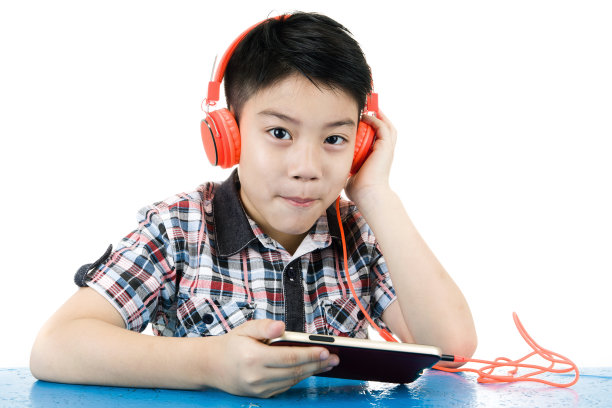 亚洲男孩戴着耳机玩手机图片下载