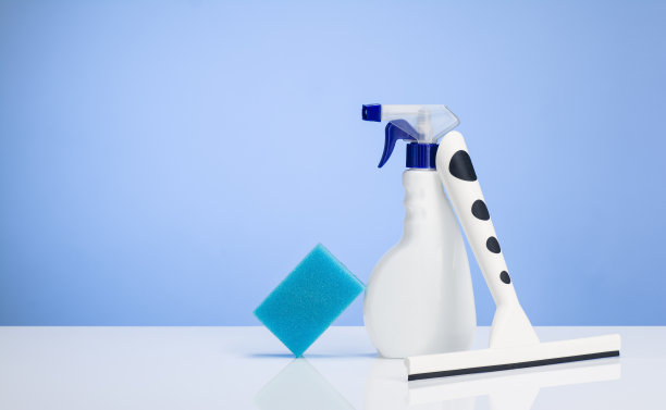 家用清洁产品在白色的桌子上，蓝色渐变的背景图片下载