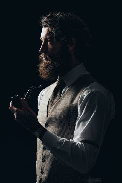 优雅的年轻帅哥拿着烟斗图片下载