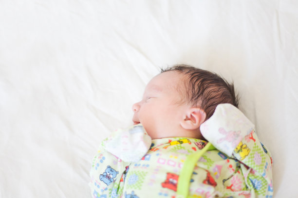 新生儿躺在白色的尿布上图片下载