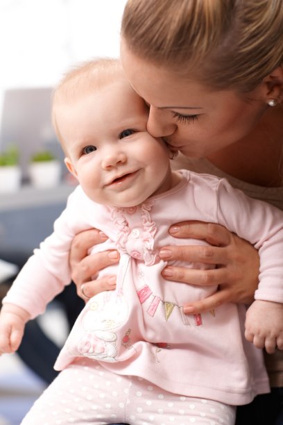 妈妈亲吻快乐的宝宝的特写照片图片下载