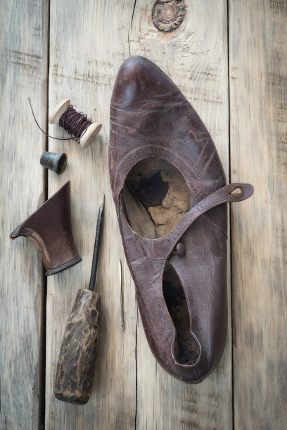 旧鞋子放在木桌上。俯视图图片下载