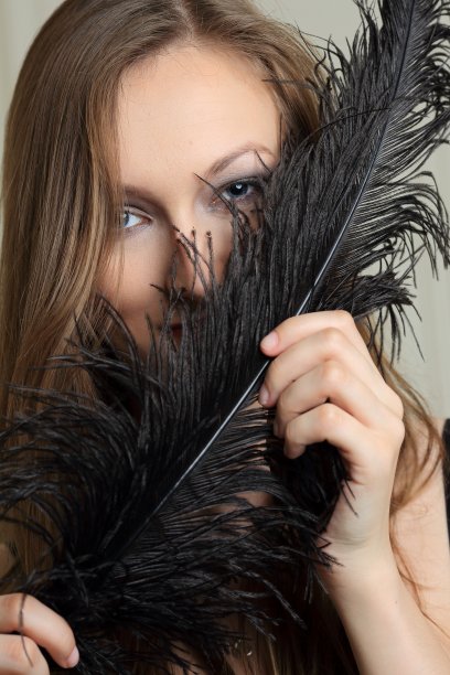 一个带着鸵鸟羽毛的年轻女人的肖像图片下载