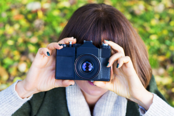 在公园里用复古相机拍照的女人图片下载