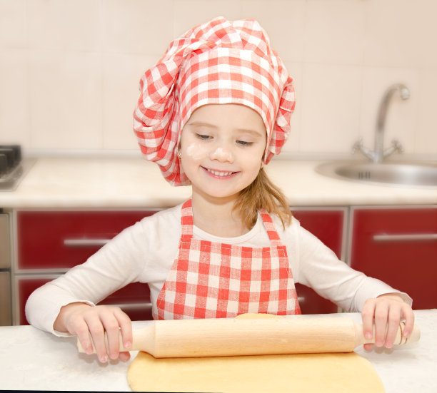 带着厨师帽微笑的小女孩在揉面团图片下载