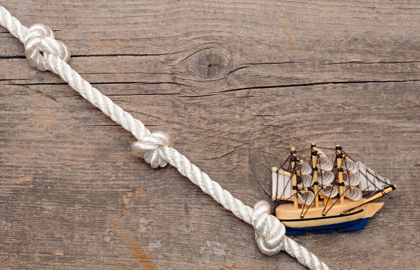 绳索和模型经典船在木材背景上图片下载