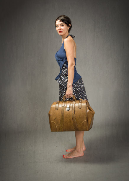 灰色背景下的女孩提着一个旧手提箱图片下载