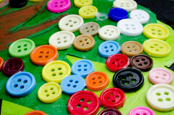 许多颜色的钮扣粘在纸上图片下载