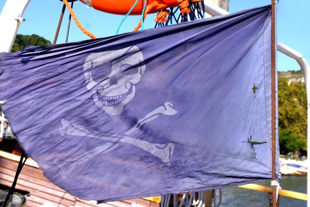 船上桅杆上飘扬着海盗的旗帜图片下载