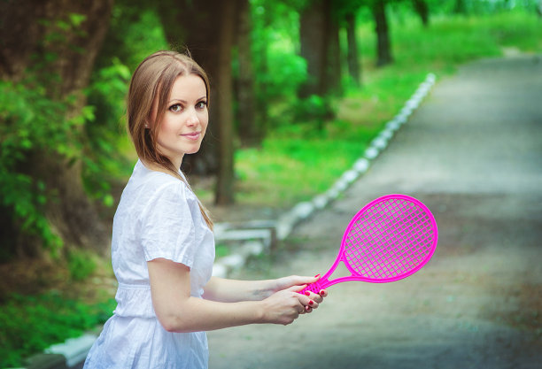 年轻女子与玩具羽毛球图片下载