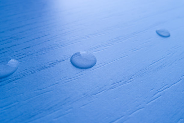 水滴在桌子的木头上。图片下载