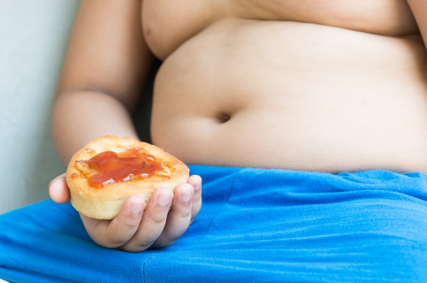 小披萨在肥胖的男孩手中。图片下载