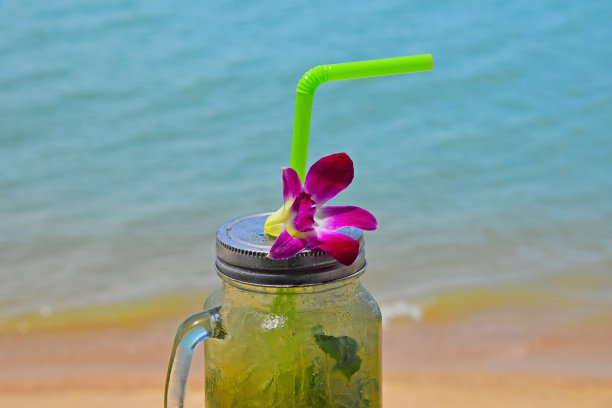 海滩上有一大杯莫吉托和兰花花图片下载