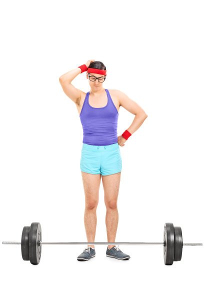 一个可疑的男运动员站在杠铃后面图片下载