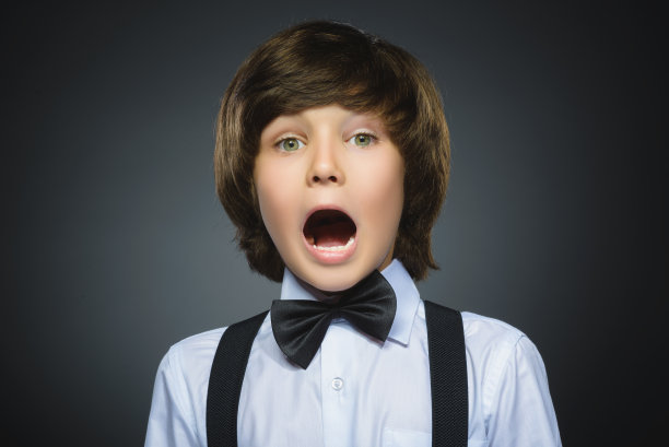 特写的英俊男孩与惊讶的表情，而站图片下载