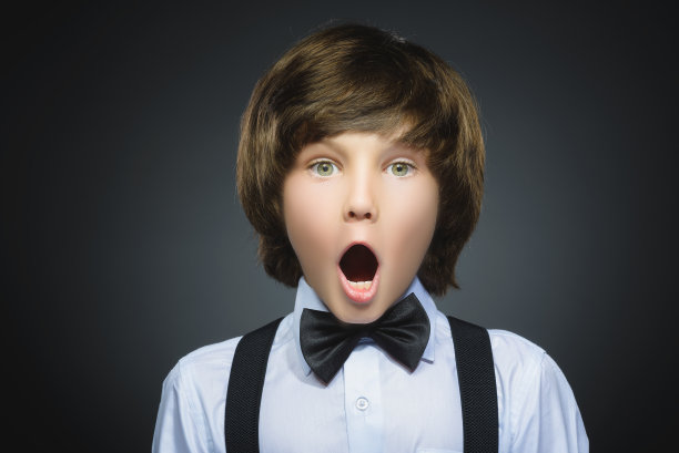 特写的英俊男孩与惊讶的表情，而站图片下载