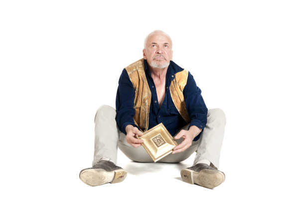 男人坐在地板上，上面有镀金的花纹图片下载