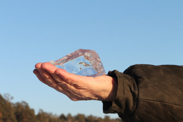 男性手中的冰晶映衬着蓝天图片下载