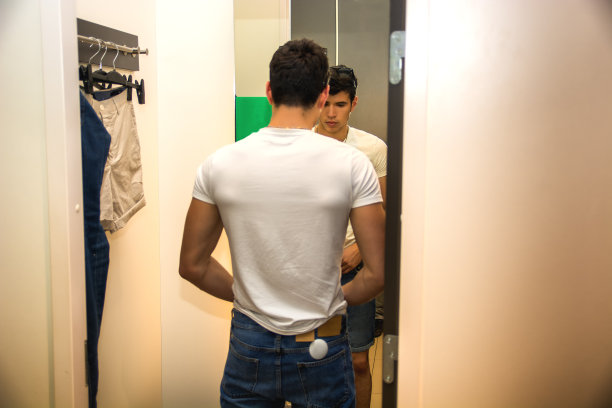 在服装店试穿衣服的年轻人图片下载