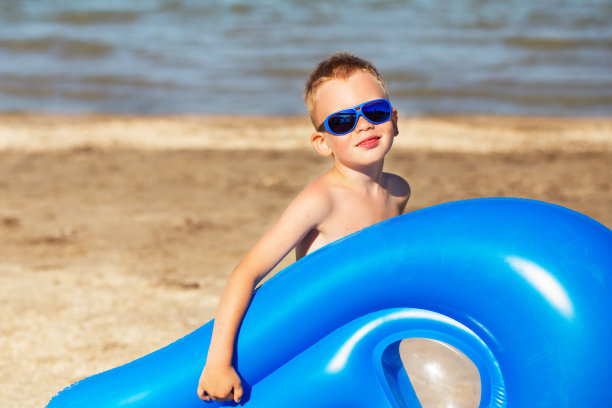 一个小孩拿着充气床垫图片下载