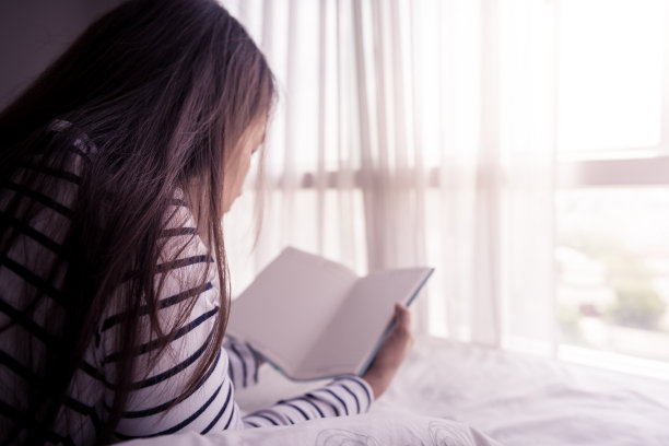 女人手里拿着打开的书图片下载