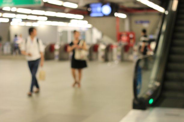 模糊的形象，人们在门或票务障碍的机场铁路连接火车站在曼谷，晚上，泰国。图片下载