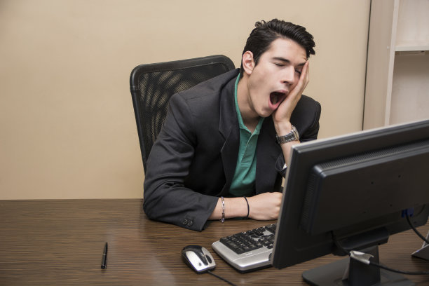 疲惫无聊的年轻商人坐在办公室打哈欠图片下载