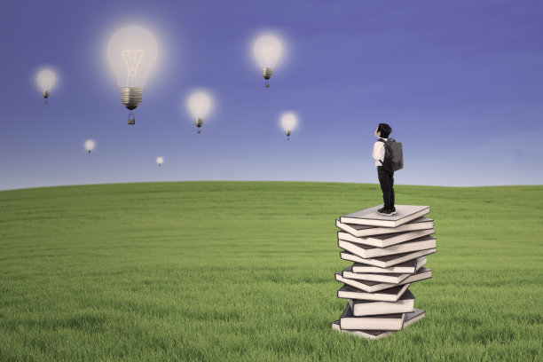 商业小孩站在书上看室外的灯泡图片下载