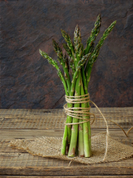 一束新鲜的绿色芦笋在木背景上图片下载
