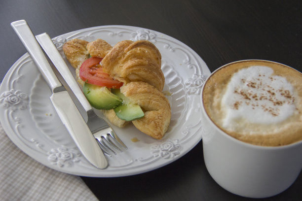 咖啡杯和新鲜出炉的羊角面包在黑色背景图片下载