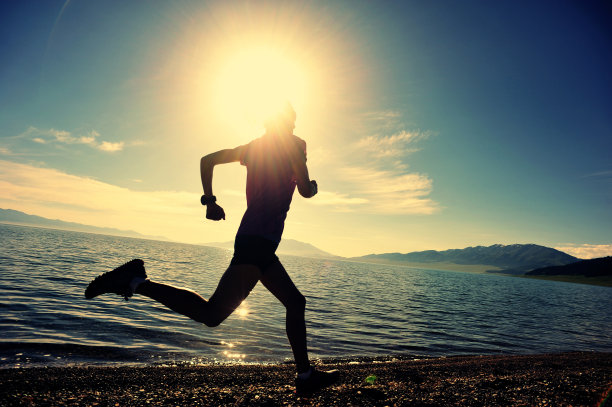 健康的生活方式，年轻女子跑步在日出的海边图片下载