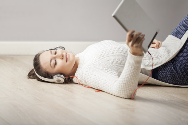 年轻女子在平板电脑上听音乐图片下载