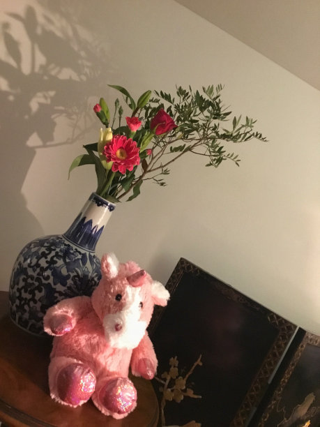 独角兽软玩具和花瓶与花图片下载