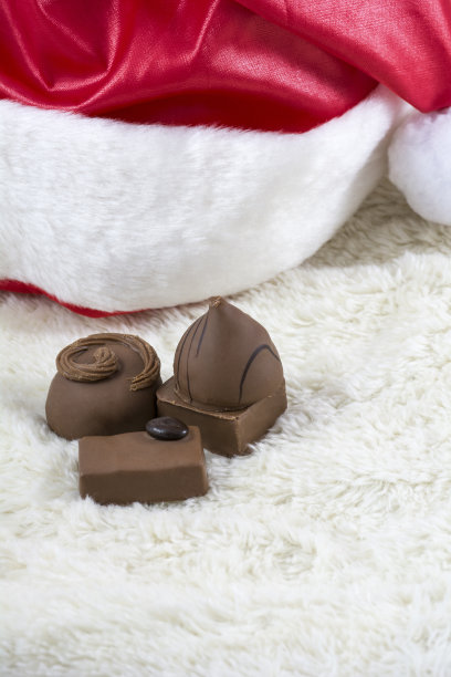 几颗巧克力糖果和圣诞帽上的白色皮毛图片下载